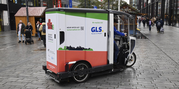 An electric parcel delivery car in a pedestrian area